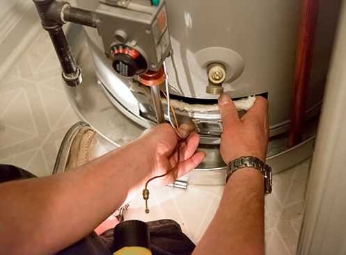 man repairing a water heater
